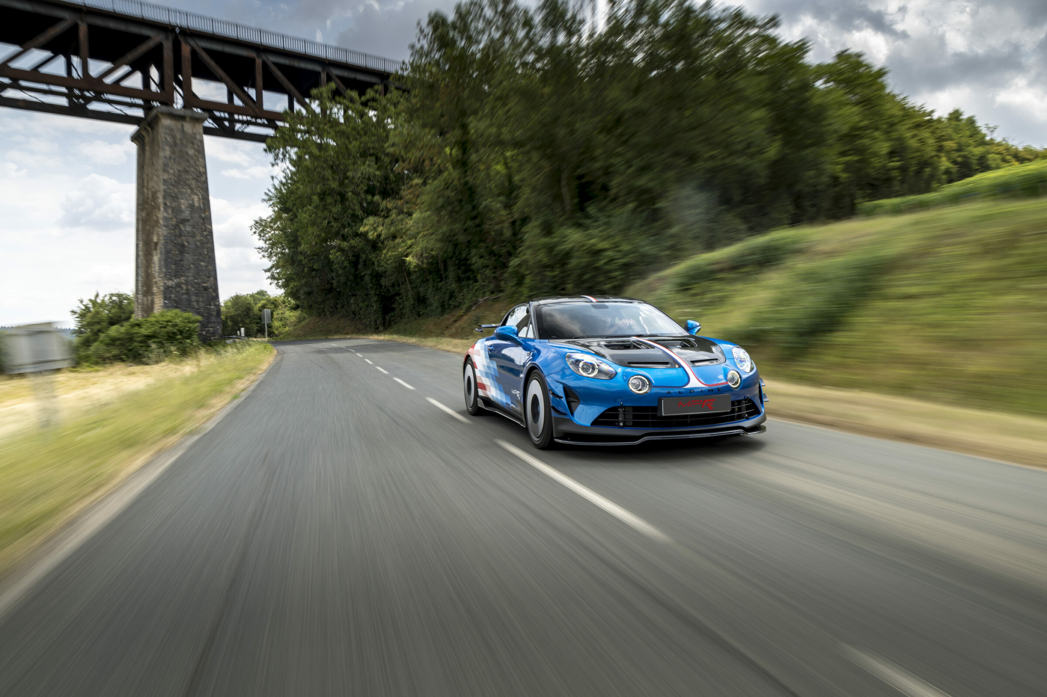 Alpine A110 R Ultime MPR en dynamique sur route, sous un viaduc
